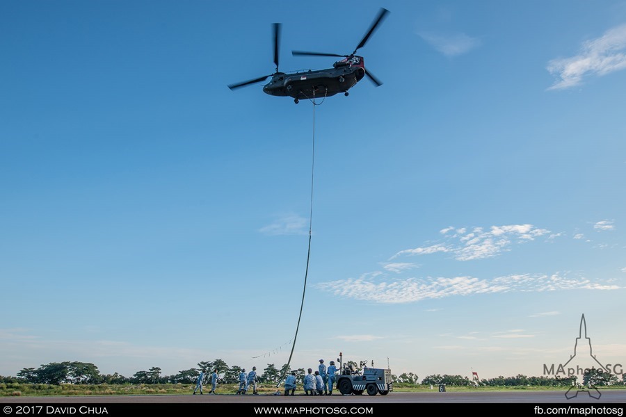 Ground crew pulls the release cable to unfurl the State Flag as the aircraft rises