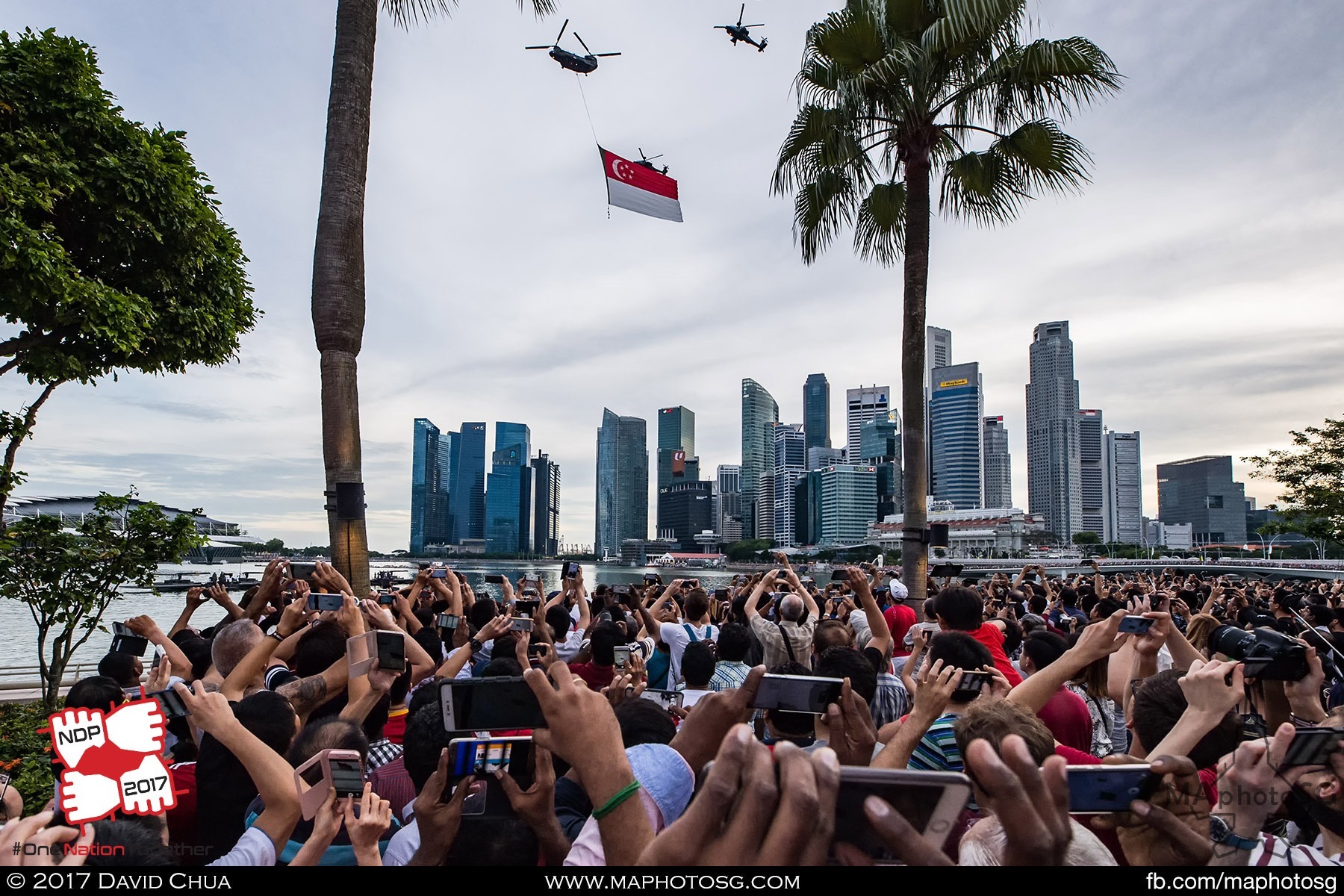 19. The state flag flies pass part of the 150000 strong crowd around the Marina Waterfront as it enters the show centre. 