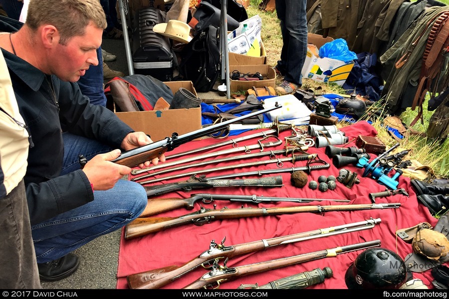 A potential buyer checks out an antique rifle