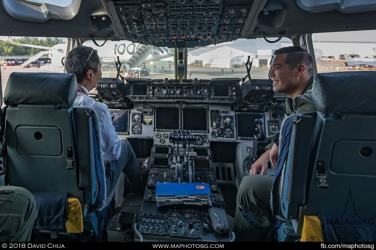 A visitor having a chat with a crew member in the cockpit of the C-17A Globemaster III