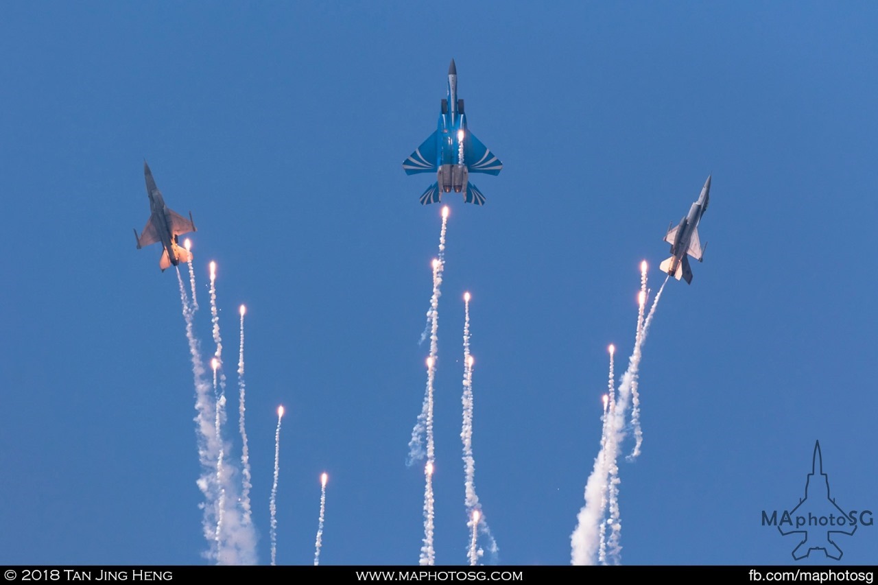 The F-15SG and F-16Cs of the RSAF Aerial Display Team pulls up into vertical and deployed a string of flares in their finale manoeuvre. The Golden Salute. 