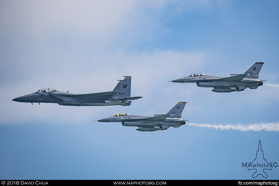 The formation of F-15SG and F-16C enters the show in arrowhead formation from the right trailing smoke