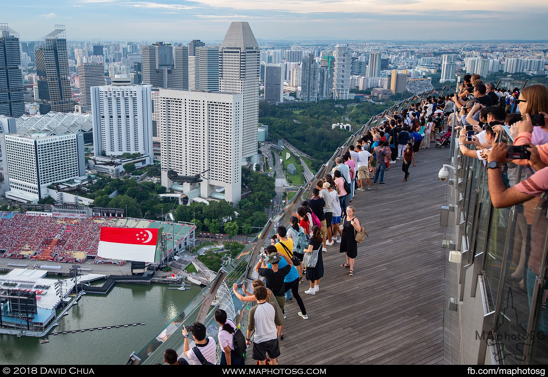 20. Visitors to the Marina Bay Sands Skypark views the state flag fly past from a high angle.