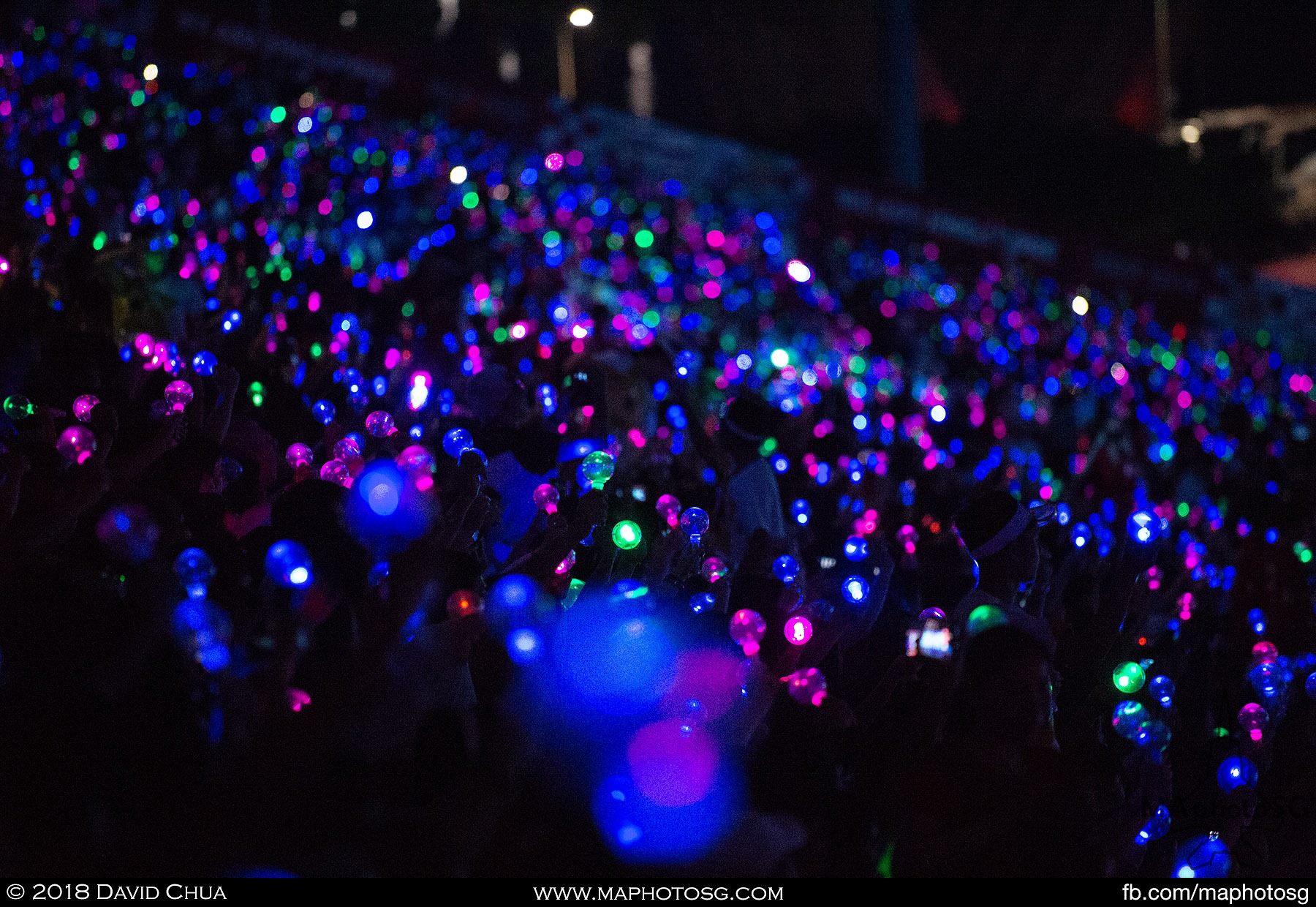 37. Spectators switch on their light bubbles as the night falls.