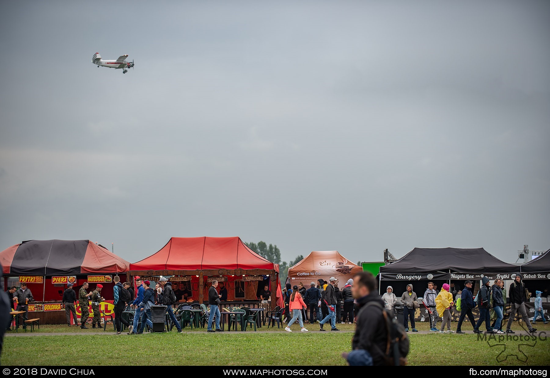 16. Antonov An-2 flies over a row of food kiosks at the Radom Airshow