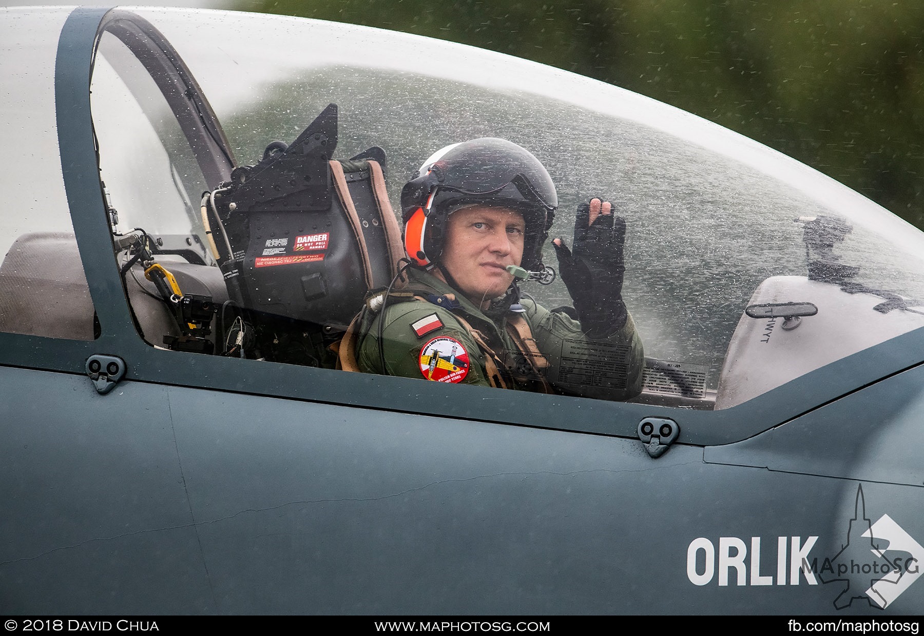 25. Pilot of a Polish Air Force Team Orlik PZL-130 waves as he taxis past the crowd