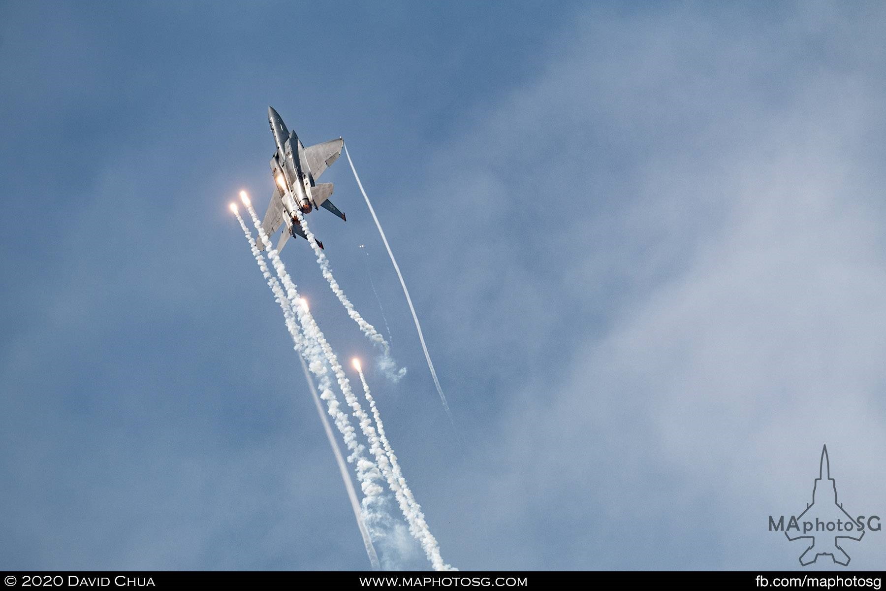 RSAF F-15SG dispensing flares as it goes veritical in the finale of the aerial display performance