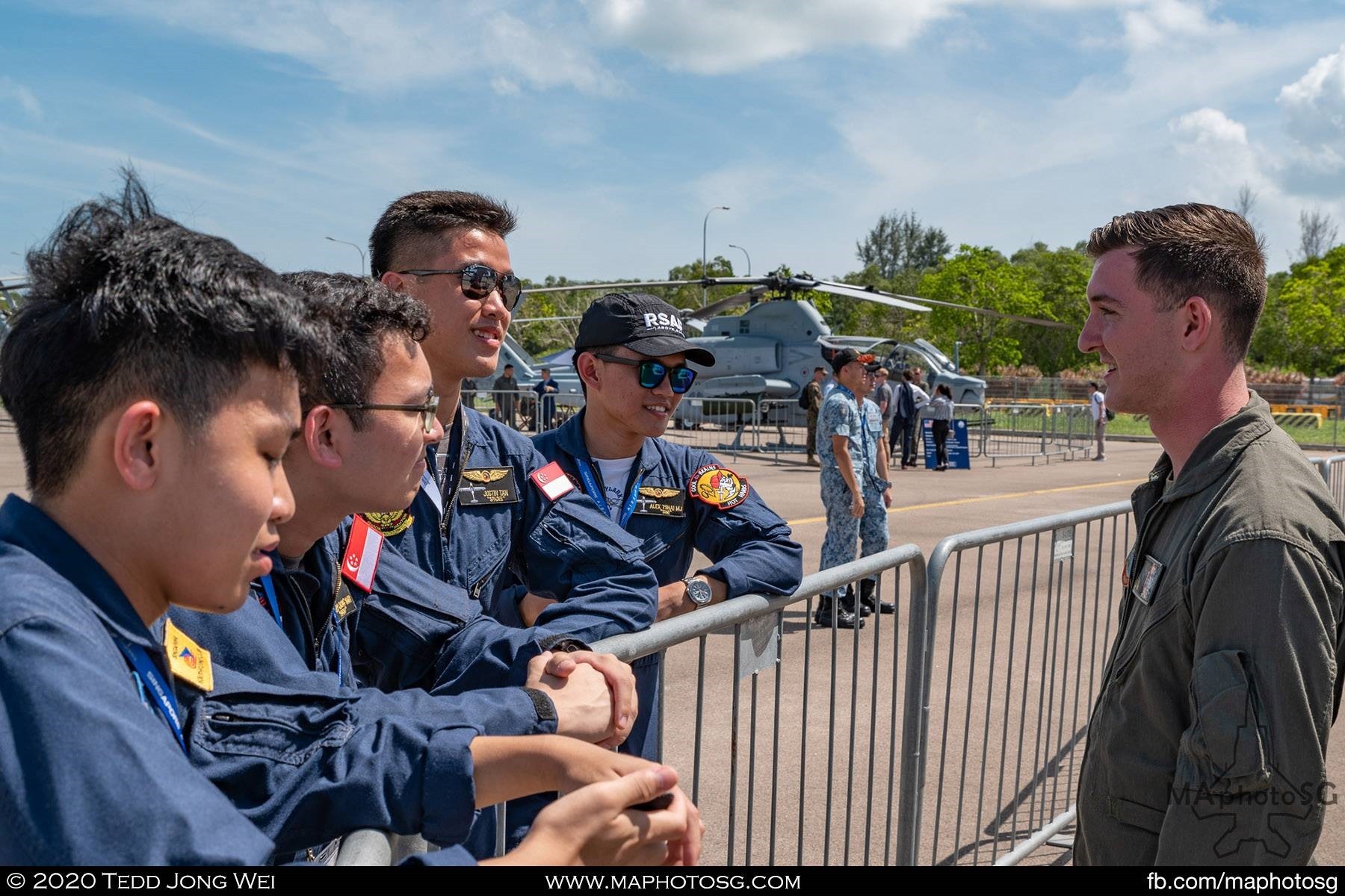 Members of the Singapore Youth Flying Club chatting with a USMC pilot