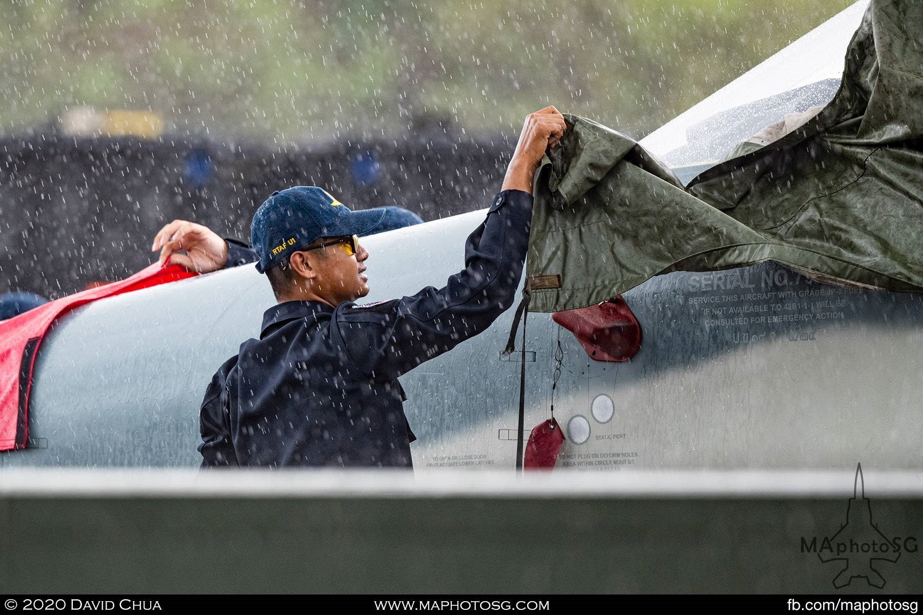 RTAF crew covers their F-5TH as the rain pours down on the opening day