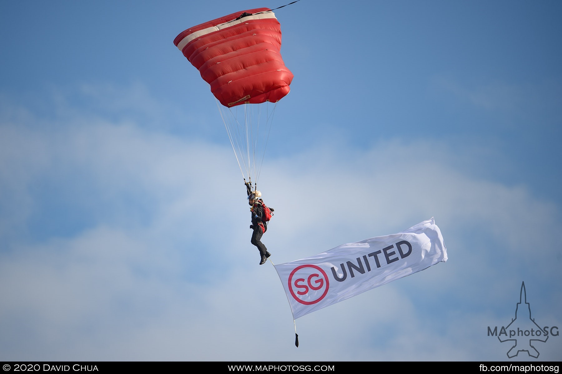 The Red Lions Freefall team member with a SG UNITED banner.