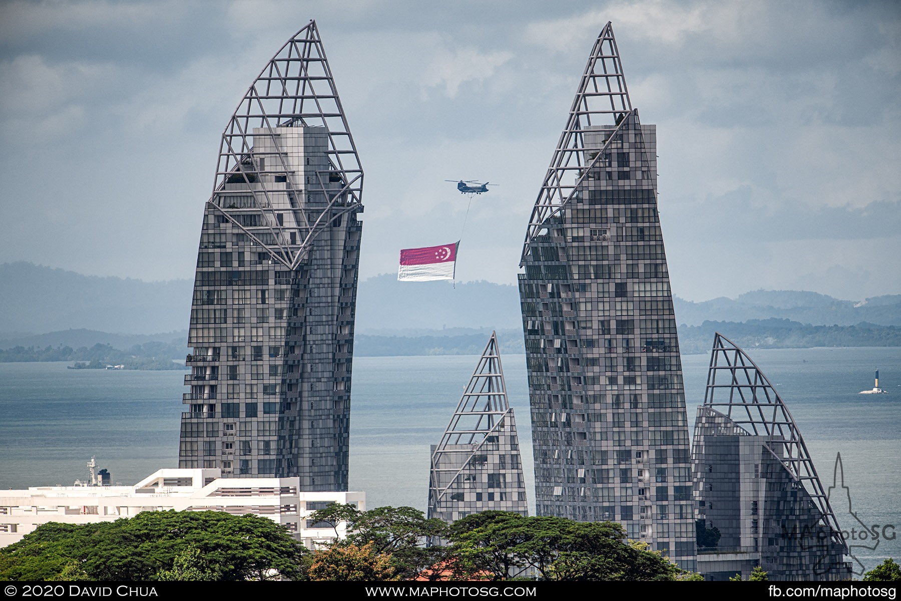 A lone CH-47D Chinook circles off the southern coast with the State Flag, awaiting the arrival of the AH-64D Apache Longbows.