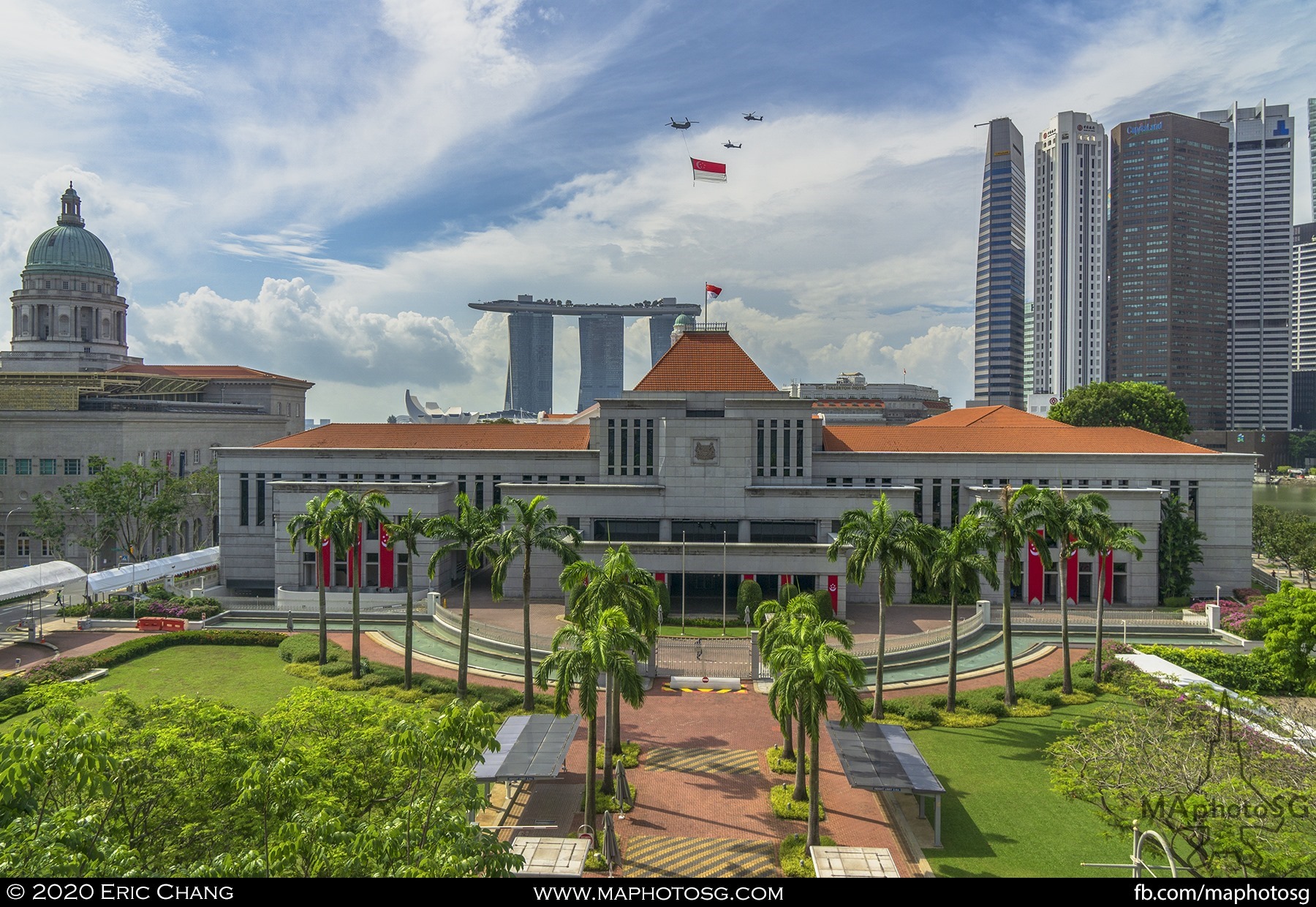 The State Flag flies past the Padang with Parliament House in the foreground.