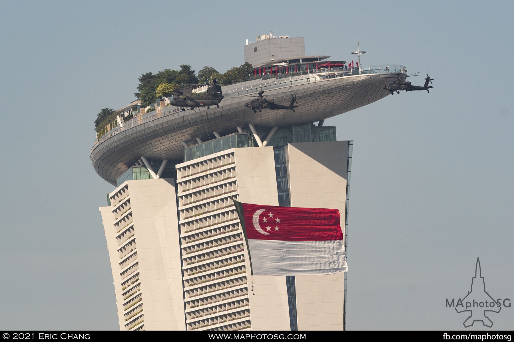 The flag party flies past the Marina Bay Sands hotel as it leaves the parade