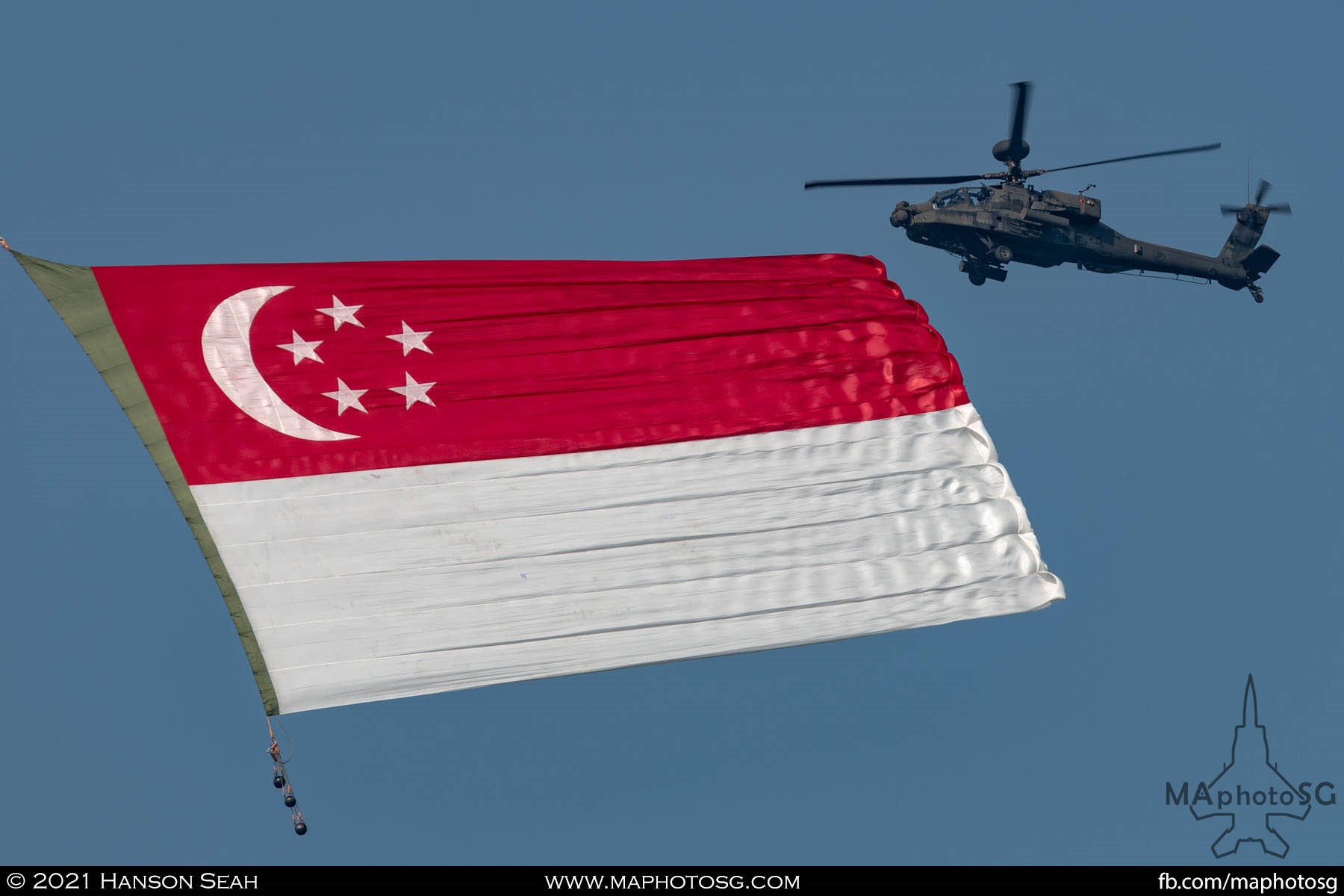 The Singapore Flag flies as the escorting Apache looks on