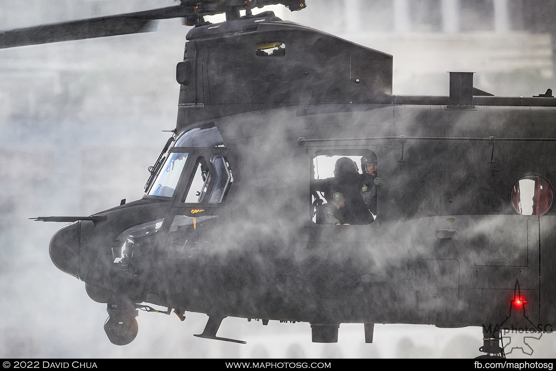 Aircrew Specialists of the Chinook looks on as the helicopter hovers above the water