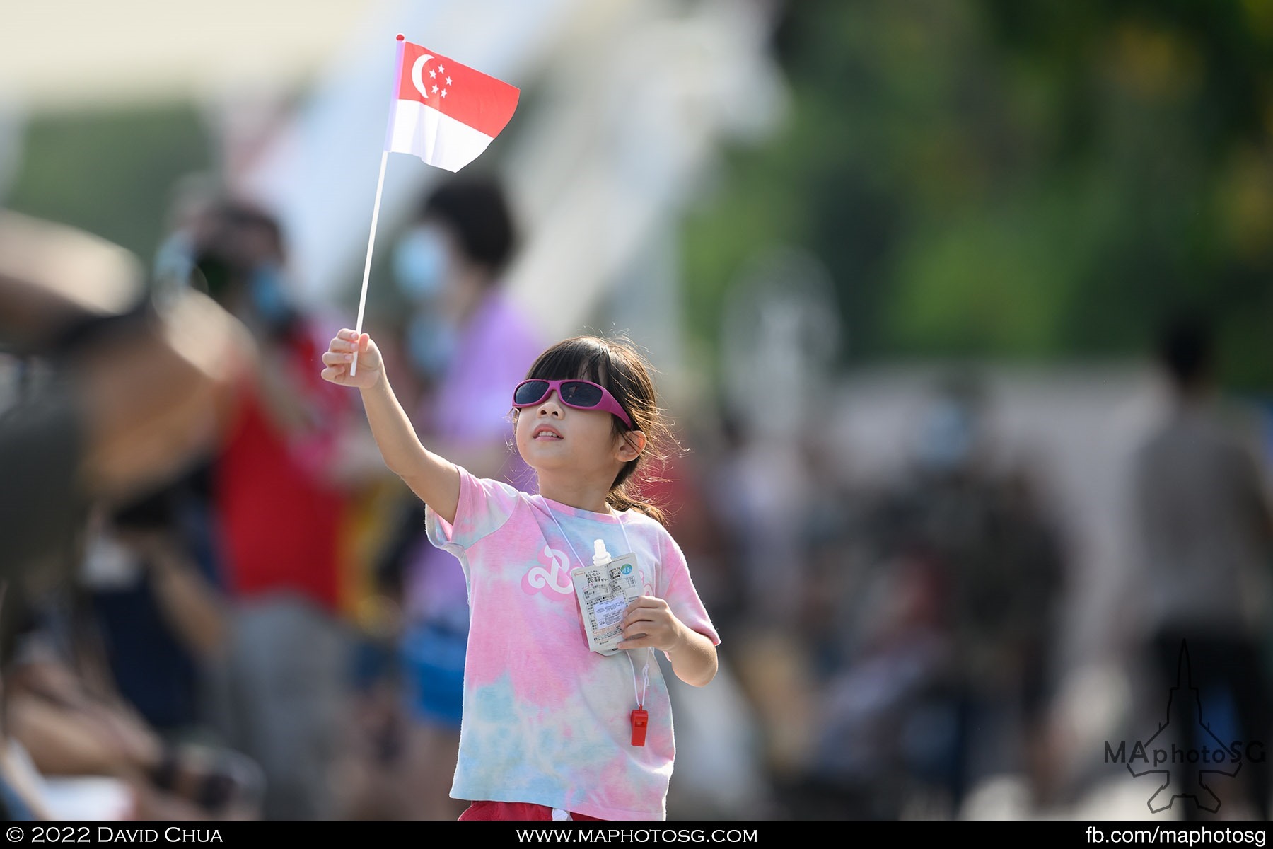 A little girl waving the Singapore Flag at the Espalande Waterfront