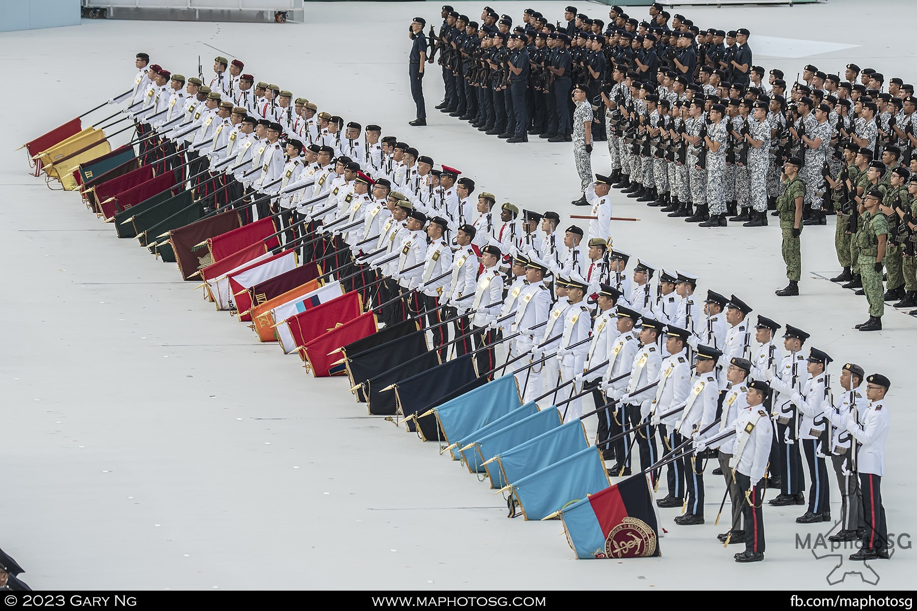 The Guard of Honour Colour Party lower their flags during the National Anthem
